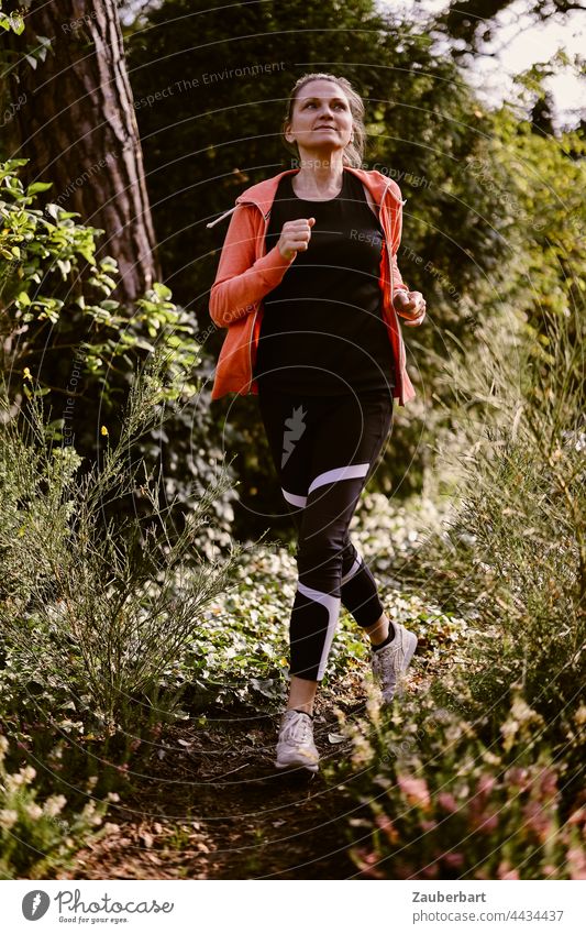Sporty woman jogging in the forest - a Royalty Free Stock Photo from  Photocase
