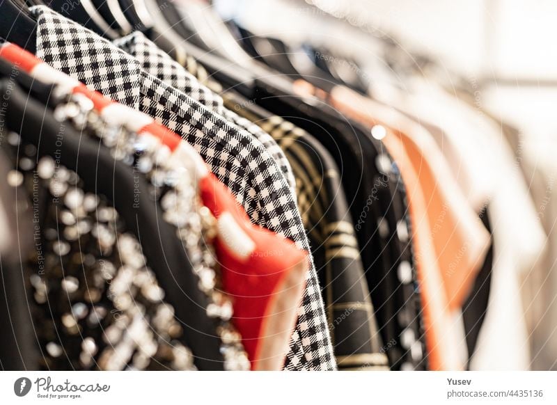 Fashionable stylish women's clothing on a hanger. Close-up of branded clothing in a show room. Light background. Fashion retail, show room, shopping or seasonal sale concept. Selective focus
