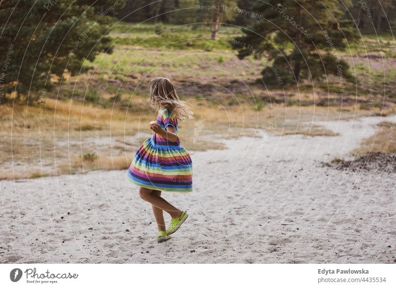 Little girl dancing in nature meadow grass field rural countryside adventure Wilderness wild
hair vacation travel active summertime day freedom holiday enjoying