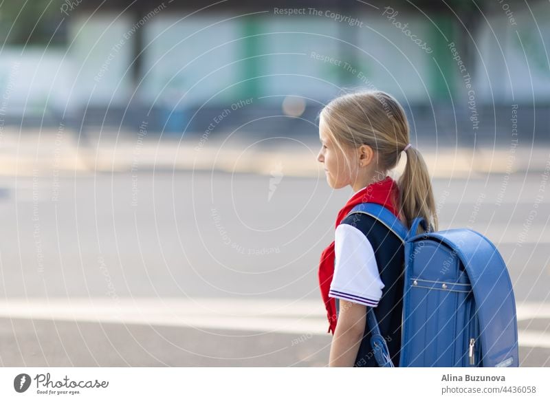 Back to school. Little girl from elementary school outdoor on bus stop. Kid going learn new things 1th september back to school child public transport backpack