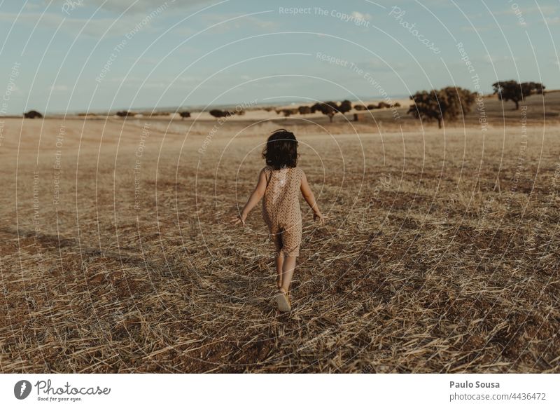 Rear view girl running through fields Child 1 - 3 years Girl Running Freedom Nature Authentic Joy Playing 3 - 8 years Infancy Exterior shot Colour photo