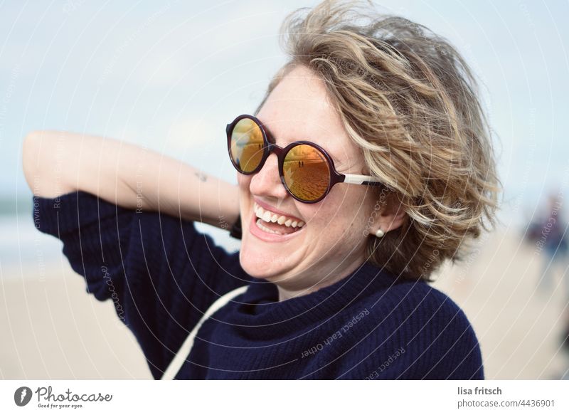 WOMAN - SUNGLASSES - AT THE SEA Woman 30-34 years Sunglasses Curl Blonde Laughter by the sea Adults Exterior shot Colour photo Joie de vivre (Vitality)