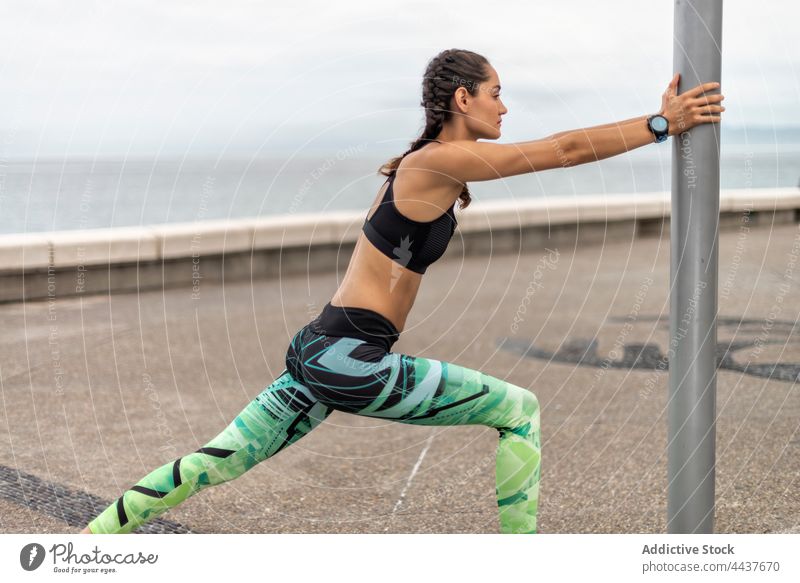 Slender sportswoman warming up during training on promenade - a Royalty  Free Stock Photo from Photocase