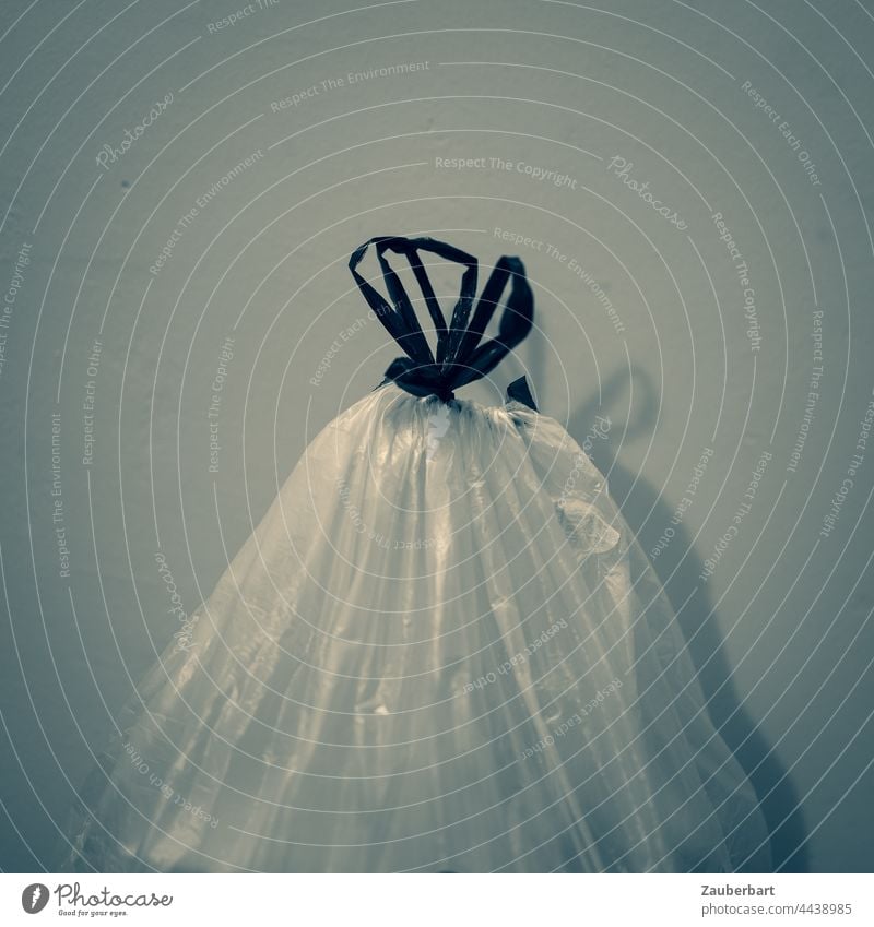 Garbage bag with bow in front of wall with shadow garbage bag Trash Recycling bag Plastic bag Bow Wall (building) Shadow Monochrome Sack Trash container