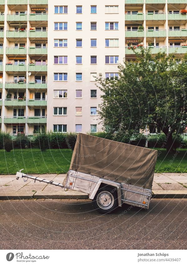Car trailer detached on road in front of apartment block Trailer Street logistics relocation storage Transport block of flats Logistics Truck Vehicle Delivery