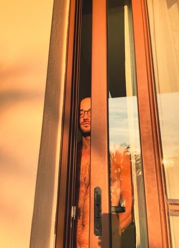 Naked man standing in the balcony door enjoying the morning sun with closed eyes Man Closed eyes in the morning Sunlight Dream To enjoy Contentment warm