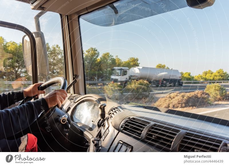 Truck driver driving on the highway, seen from inside the cab. truck driver cabin steering wheel transport working men hauler vehicle teamster transportation