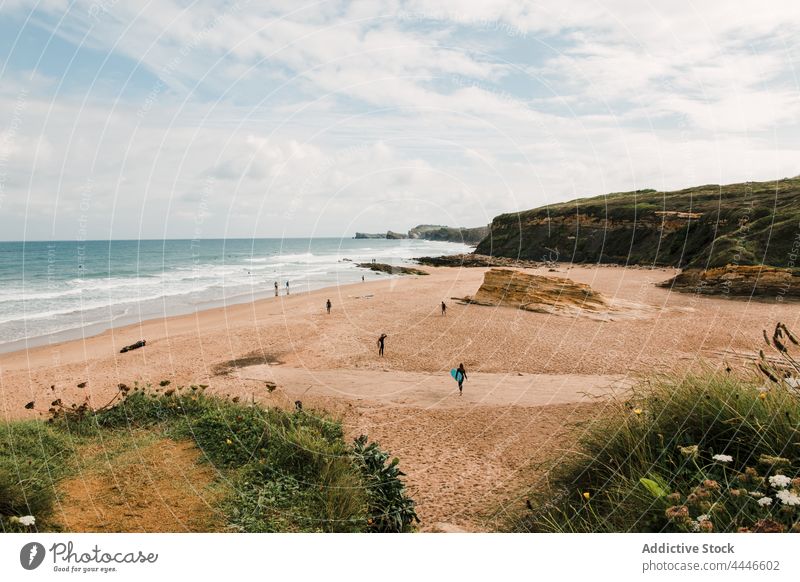 Tourists on sea shore against cliff in summer tourist mount cloudy sky nature seascape highland landscape vacation tourism together group grass people