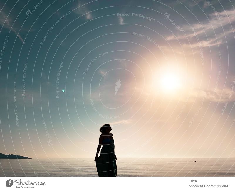 Dark silhouette of a woman by the sea looking up to the shining sun Silhouette Woman Beach Ocean Sun sunshine Black Water coast Horizon Sunrise Sunlight