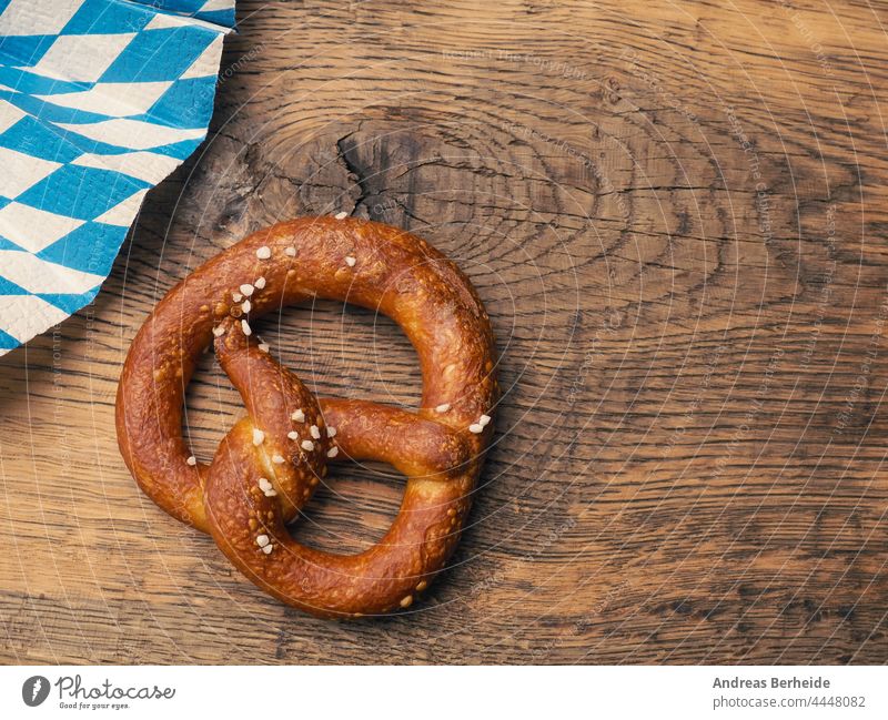 Tasty pretzel with Bavarian flag on a rustic wooden table germany munich oktoberfest bavaria twisted crunchy original pastries delicious tradition invitation