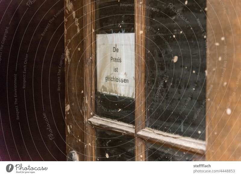 Improvised "practice closed" sign in a window of a wooden door after the flood in the Ahr valley Day Entrance Window Medical practice Doctor medical practice