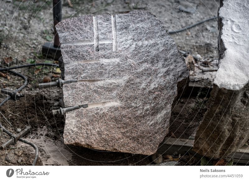 splitted granite boulder rock. Splitting with drilling holes and typing wedges. Then nailed them with hammer that makes stone crack in two pieces. Used in building industry and stonemasonry