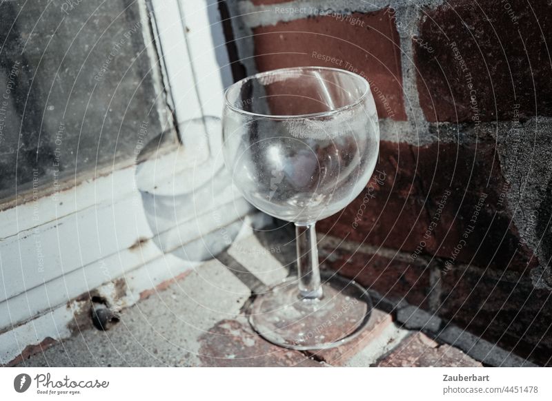 Used wine glass placed on windowsill in front of old frame and brick wall Wine glass utilised Lips Lip print Window frame bricks Corner turned off switch off