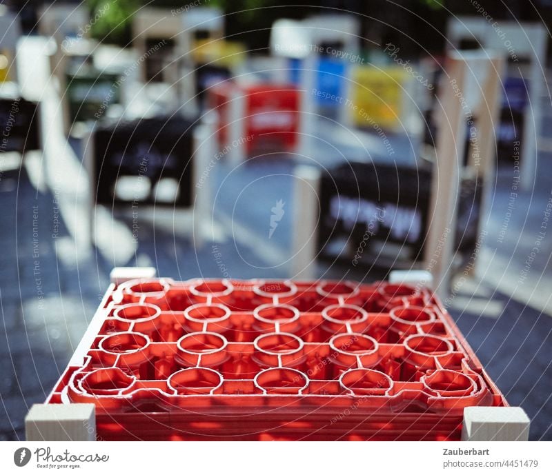 Red beverage crate as seat of a stool, creative chairs made of beverage crates in the background drink Beverage box Stool Chair Plastic creatively Art Sit