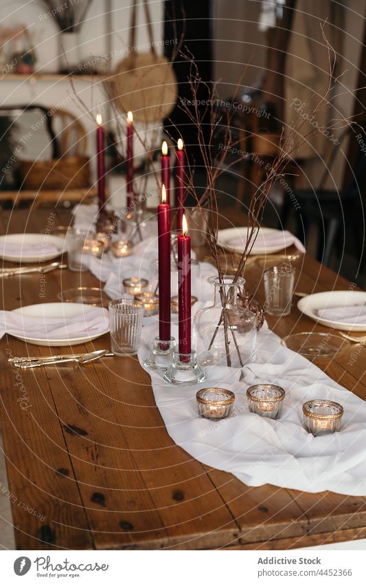 Served festive table with burning candles decoration event serve creative celebrate plate design christmas branch tablecloth table setting decorative banquet