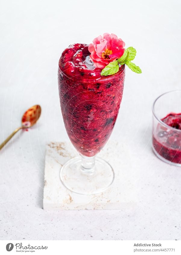Glass with berry smoothie on table glass serve sweet delicious drink refreshment healthy dessert tasty organic flower garnish treat beverage yummy nutrition