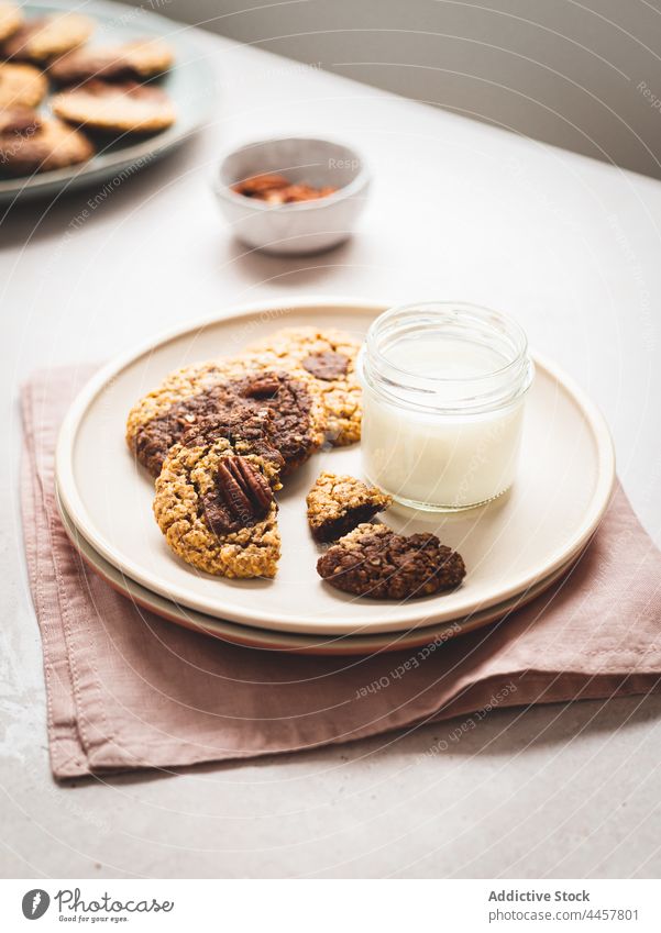 Milk and cookies on plate milk glass walnut dessert table serve sweet treat delicious snack tasty fresh nutrition food beverage healthy drink dairy pastry meal