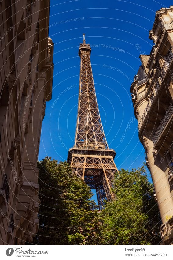 Detail of the Eiffel tower with residential buildings Tower monument Paris France oversize historical building city french landmark house built structure