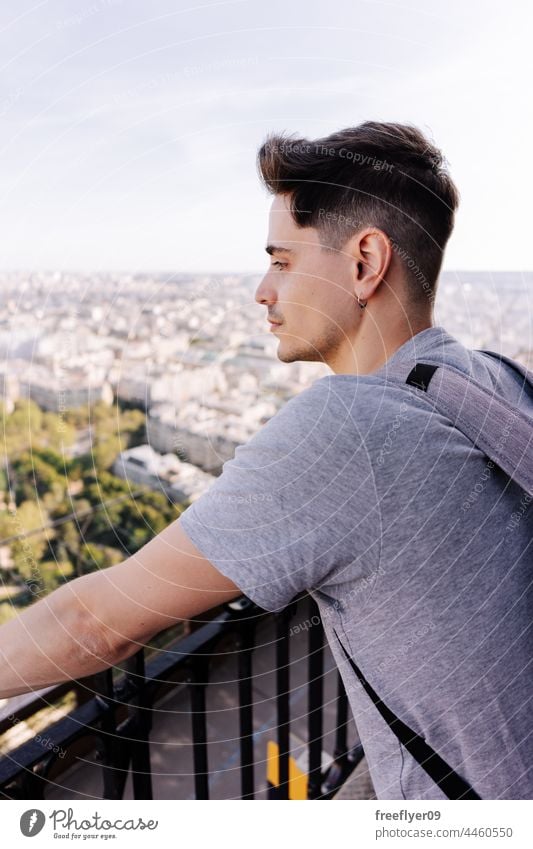 Tourist contemplating Paris from the Eiffel tower contemplate tourist eiffel man altitude Building travel tourism copy space Backpack France hiking city urban