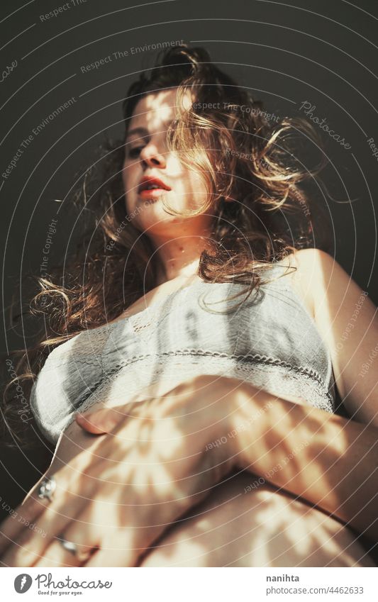 Body positive portrait of a young woman with light and shadows - a