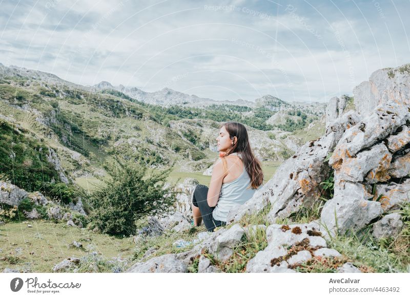 Woman hiking in mountains and looking at the scenic view and magic lands, traveling walking, healthy lifestyle, copy space enjoyment freedom horizontal person