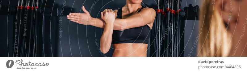 Woman stretching her arms in fitness class panoramic unrecognizable sportswoman gym copy space exercise body healthy indoors training workout aerobic coach