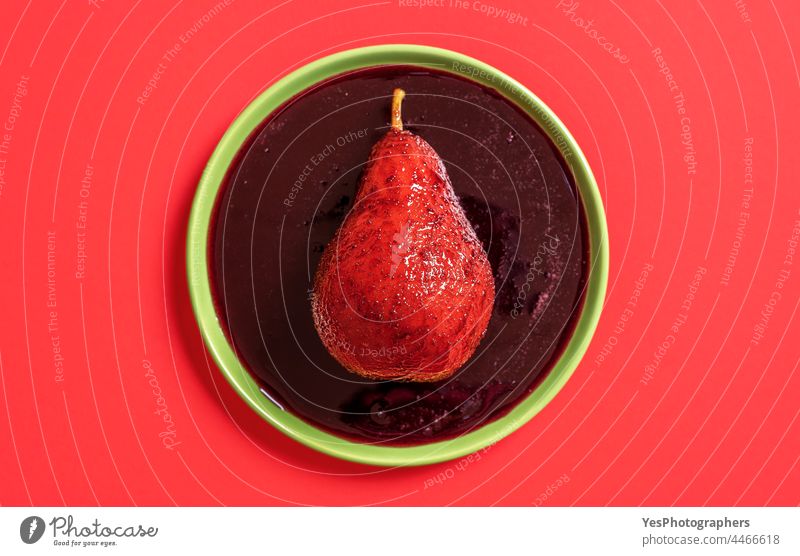 Red wine poached pear on the plate, above view. alcohol autumn background boiled christmas color cuisine cut out delicious dessert diet food french fruit