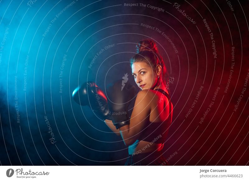 Caucasian woman boxing with colored gels and smoke fighter girl studio power exercise fitness hit lifestyle sport training caucasian female boxer young