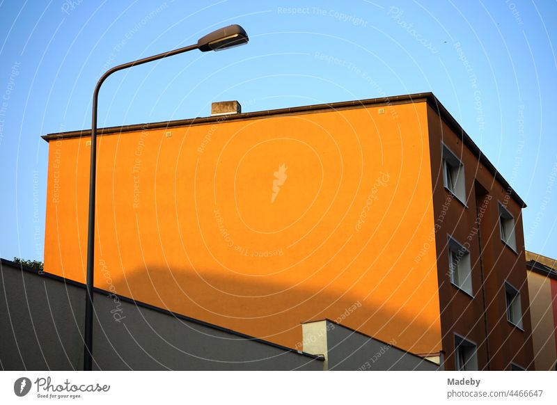 Orange painted facade without windows with street lamp in the light of the evening sun in the Bornheim district in Frankfurt am Main in Hesse