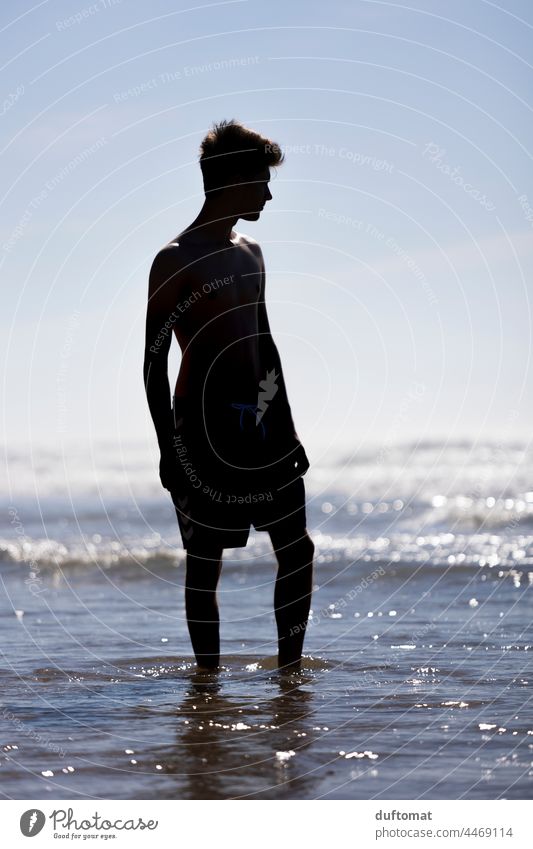 Silhouette image of a young man standing in the sea water Water Man Ocean Waves Surf Human being Young man Beach Boy (child) Relaxation young adult coast