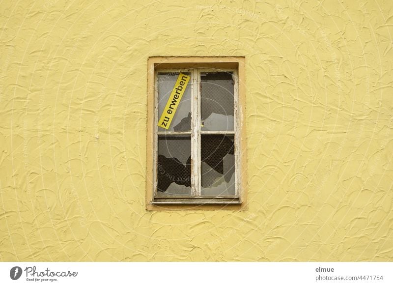 a yellow wall of a house with a broken window and the sign - to acquire -. real estate obtainable House (Residential Structure) Real estate market Pane Window
