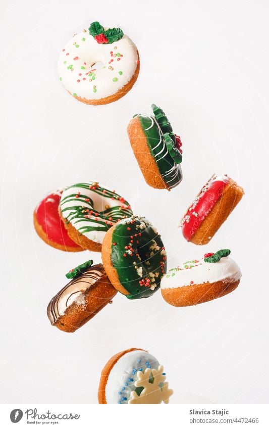Flying Christmas donuts. Colorful doughnuts with sprinkles falling or flying in motion against white background 3d american bakery bread breakfast cake