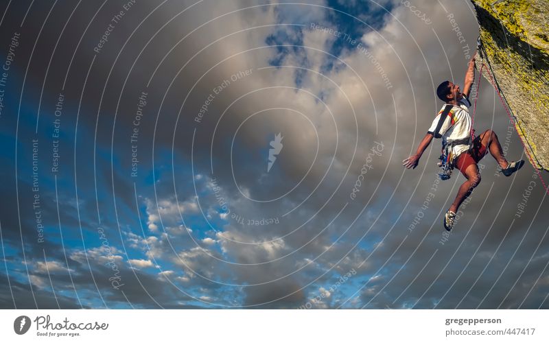 Ethnic climber dangling from the edge. Adventure Climbing Mountaineering Success Masculine 1 Human being 18 - 30 years Youth (Young adults) Adults Clouds Peak