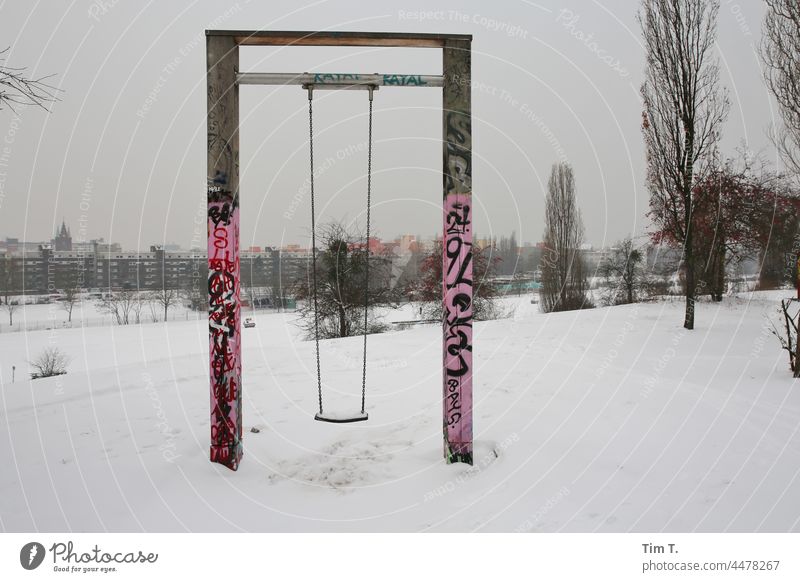 a swing in winter and snow . wall park Berlin Winter Prenzlauer Berg Snow Town Exterior shot Capital city Downtown Deserted Swing Graffiti Playground