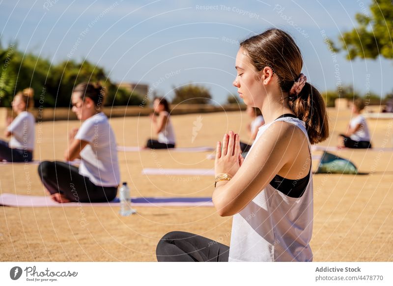 Women doing crescent lunge on knee with hands interlaced during