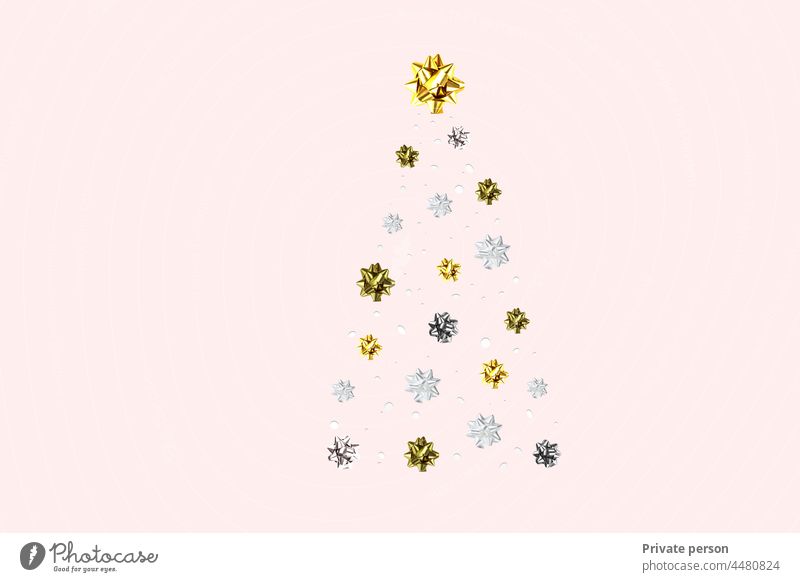 Christmas tree on a pink background. Golden Christmas tree as a symbol of a happy New Year, Christmas celebration. Golden light decoration. shiny new year greeting card design in pastel colors