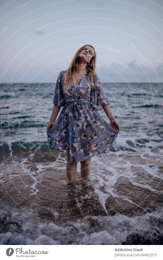 Woman in stylish dress standing on seashore woman summer evening beach trendy sunset sundown sky female delight happy style coast joy water rock seaside glad