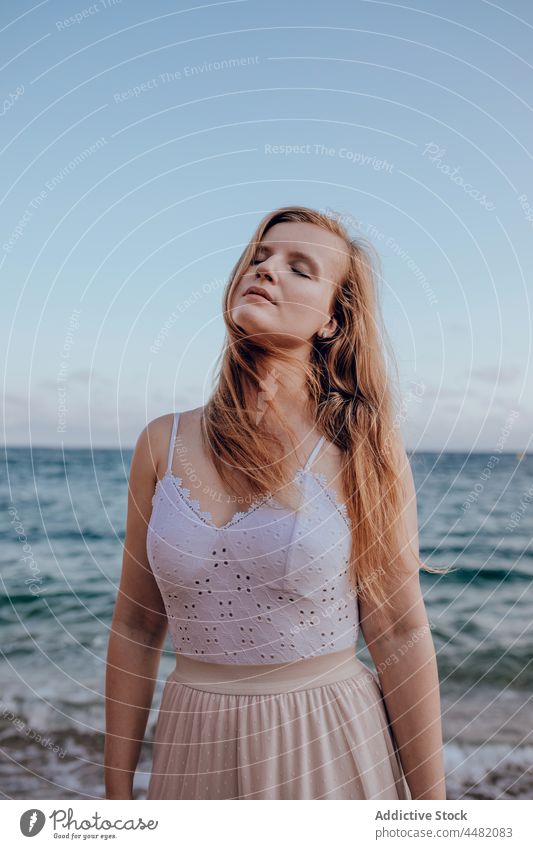 Charming woman with long hair on beach seashore appearance portrait nature evening summer water female young attractive calm gorgeous coast peaceful confident