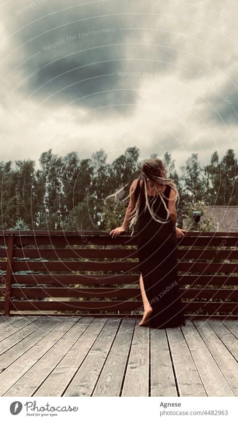 Girl with dreadlocks before the storm Woman Dreadlocks Wine Wine glass black sky Storm Storm clouds stormy stormy sky stormy atmosphere Wind hair in the wind