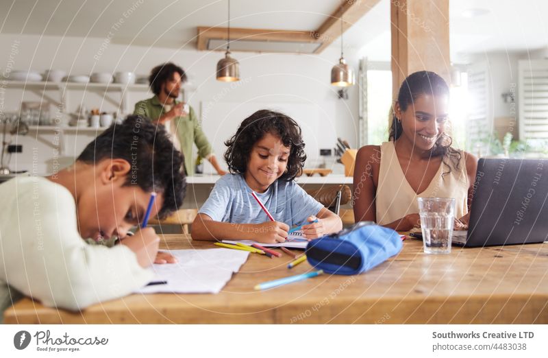 Boys doing homework with mother working from home mixed race boy child dedication education homeschool learn indoors day interior four people portrait authentic