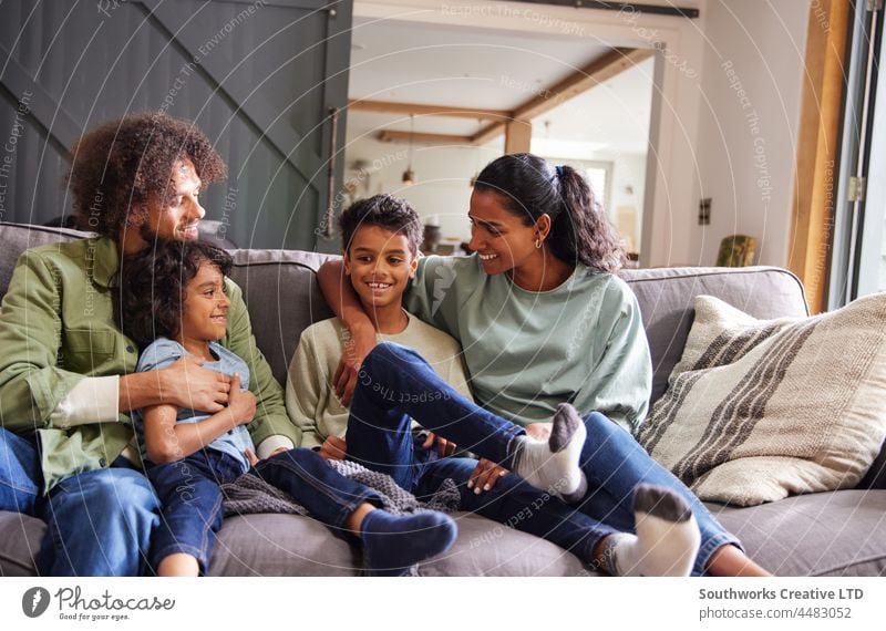 Portrait of happy family on sofa mixed race asian portrait weekend relax love together indoors day home interior four people authentic childhood leisure parent