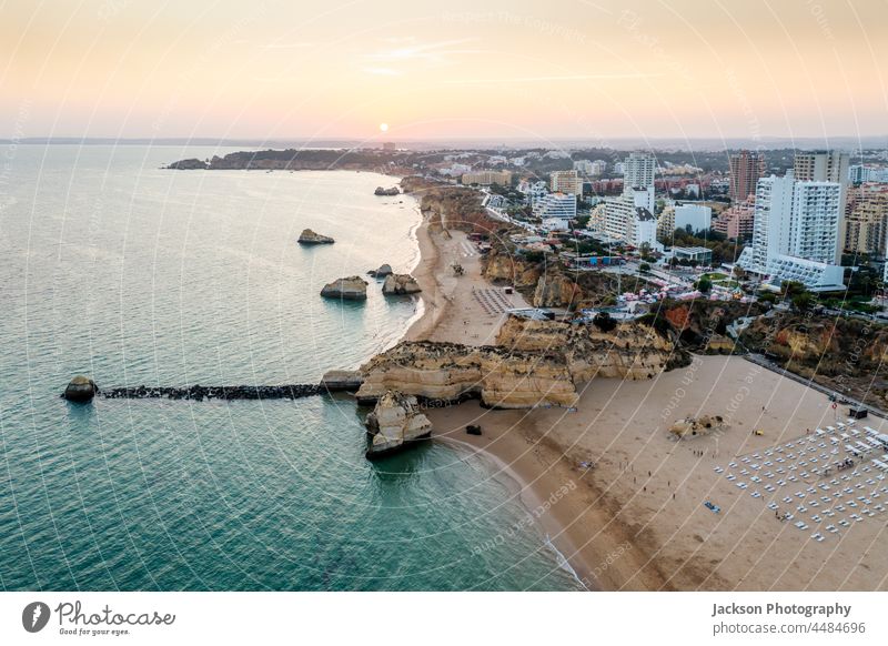 Aerial view of the coast in Portimao by sunset, Algarve, Portugal algarve portimao sea beach cliffs rocha beach limestone seaside drone shot aerial view