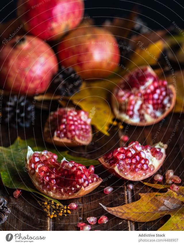 Pieces of ripe pomegranate on wooden table autumn leaf red sweet piece part fall natural fresh season harvest design composition organic vegan nutrition foliage