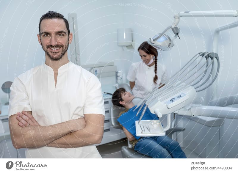 A portrait of a dentist with his team working in the background Dentist concentration examining patient assistance assistant expertise hygiene indoor occupation