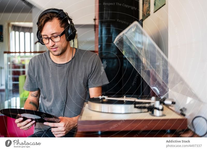 Guy in headphones listening to music from player man meloman sound melody record turntable eyeglasses song concentrate nostalgia vintage retro male