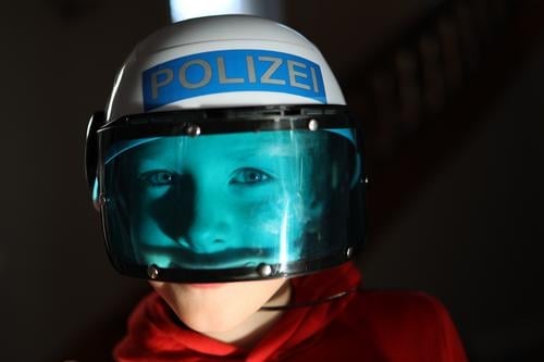 Boy playing with police helmets and blue visor Boy (child) Police Force Gun sight Blue Scare game children Infancy fun Playing free time Red Child Joy Dress up