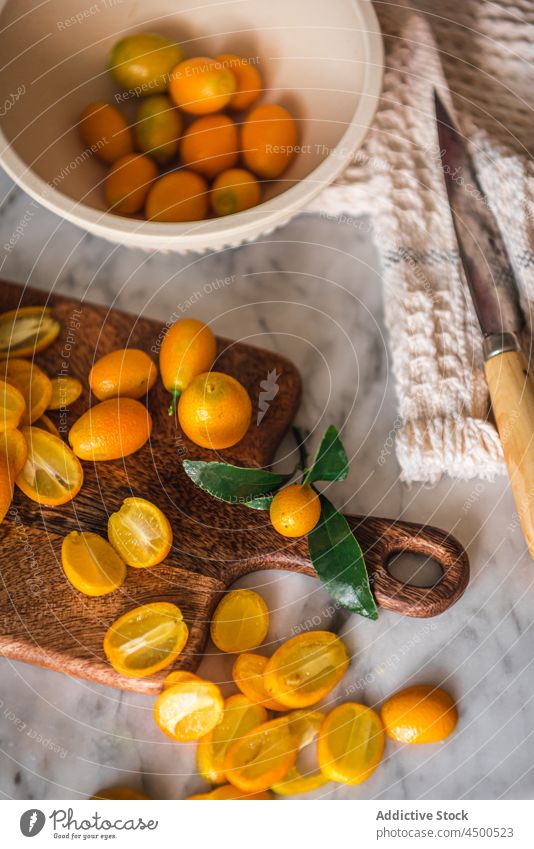 Heap of kumquats on cutting board fruit organic natural healthy food citrus vitamin kitchen fresh ripe wooden chopping board nutrition marble orange tasty pile