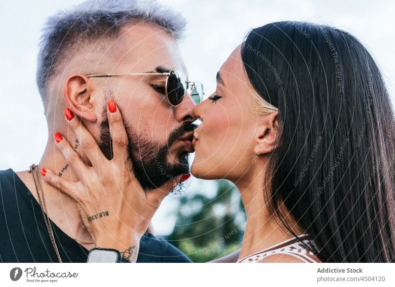 Romantic couple kissing on street in daytime relationship eyes closed romantic touch face trendy bonding partner in love boyfriend girlfriend sunglasses date