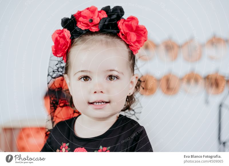 portrait of beautiful one year old caucasian girl in halloween costume at home with Halloween decoration, Lifestyle indoors. Halloween party concept. happy