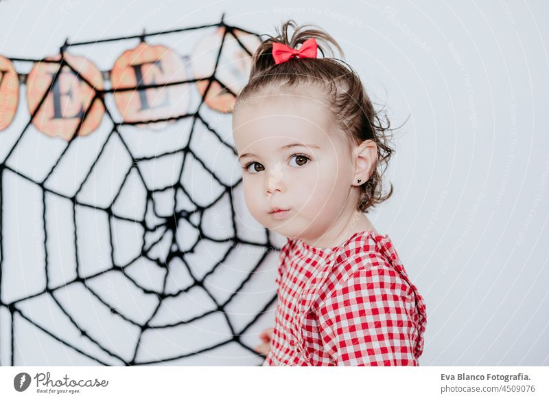 close up portrait of beautiful one year old caucasian girl at home with Halloween decoration, Lifestyle indoors. Halloween party concept. halloween costume